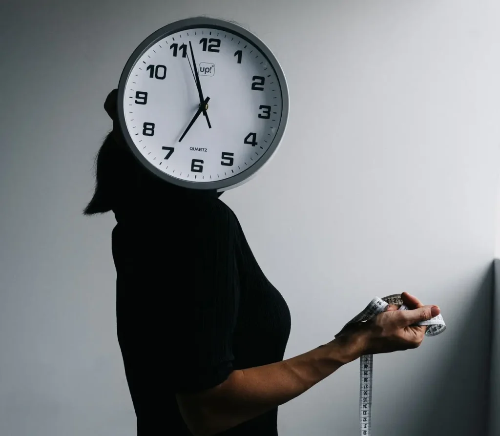mulher com relógio na cabeça e fita métrica na mão pergunta-se Quanto tempo demora para começar a emagrecer?