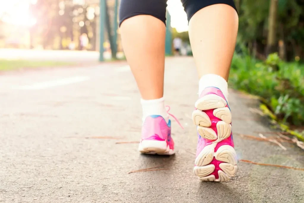 Mulher com ténis de corrida a caminhar e a questionar-se "Afinal a caminhada faz emagrecer?"